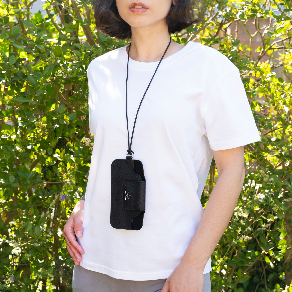Zwarte MAESE String Bag gedragen over een wit T-shirt